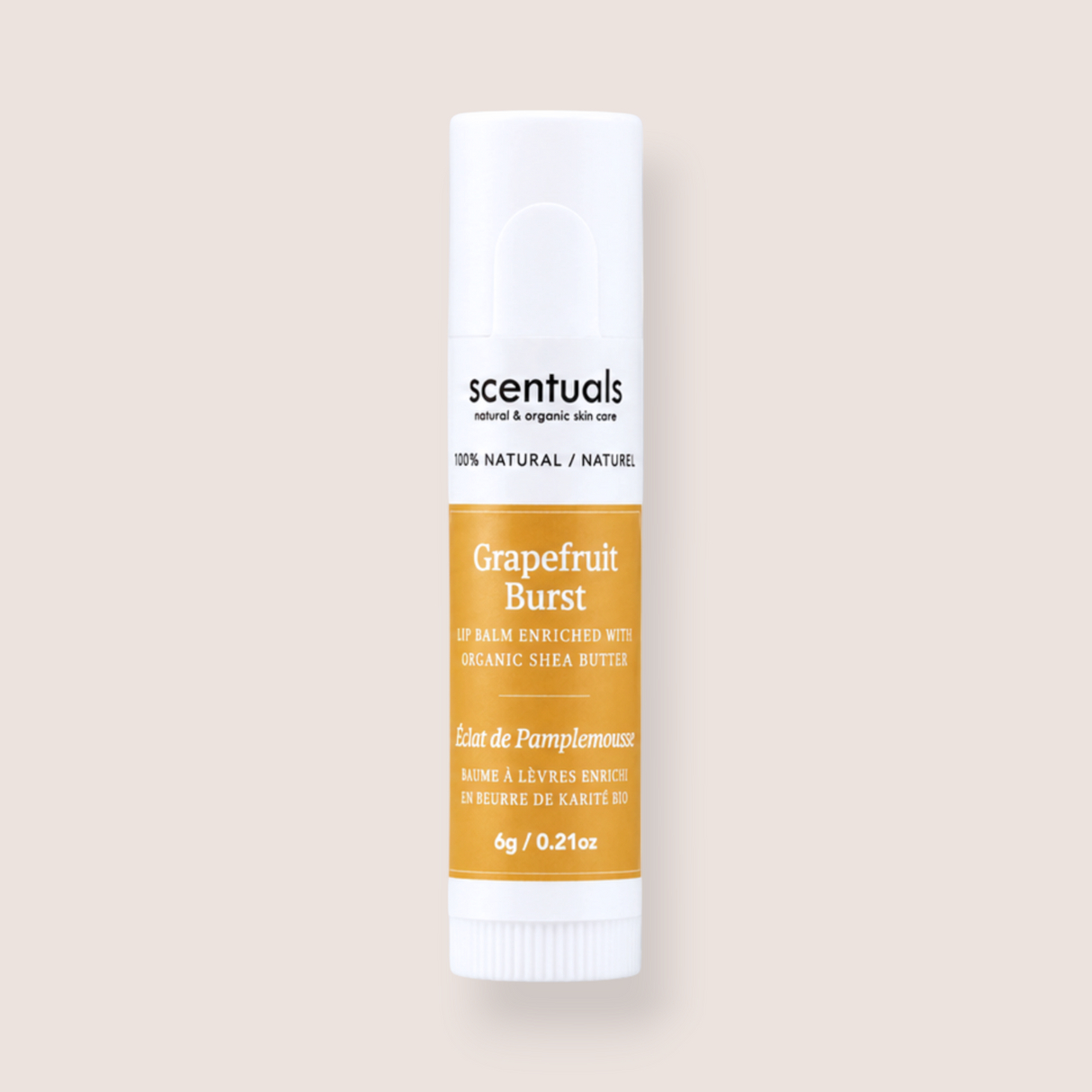 A single tube of scentuals Grapefruit Burst lip balm on a solid light beige background. The tube is white with a prominent orange-yellow label and black text.