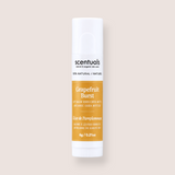 A single tube of scentuals Grapefruit Burst lip balm on a solid light beige background. The tube is white with a prominent orange-yellow label and black text.