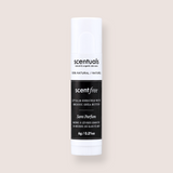 A single tube of Scentuals Scent Free lip balm with organic shea butter, shown against a solid, warm off-white background.