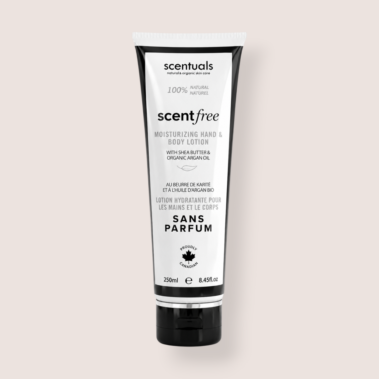 A squeeze tube of scentialss Scentfree Moisturizing Hand & Body Lotion on a solid light beige background. The tube is white with black text and black caps on the top and bottom.