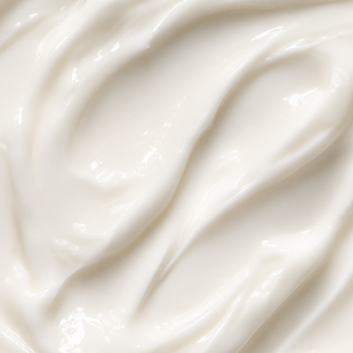 A close-up texture shot of a thick, creamy off-white cosmetic cream with smooth, glossy swirls.