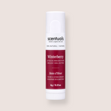 A single tube of Scentuals Winterberry lip balm, featuring a white cap and base with a deep red label, centered on a light beige background.